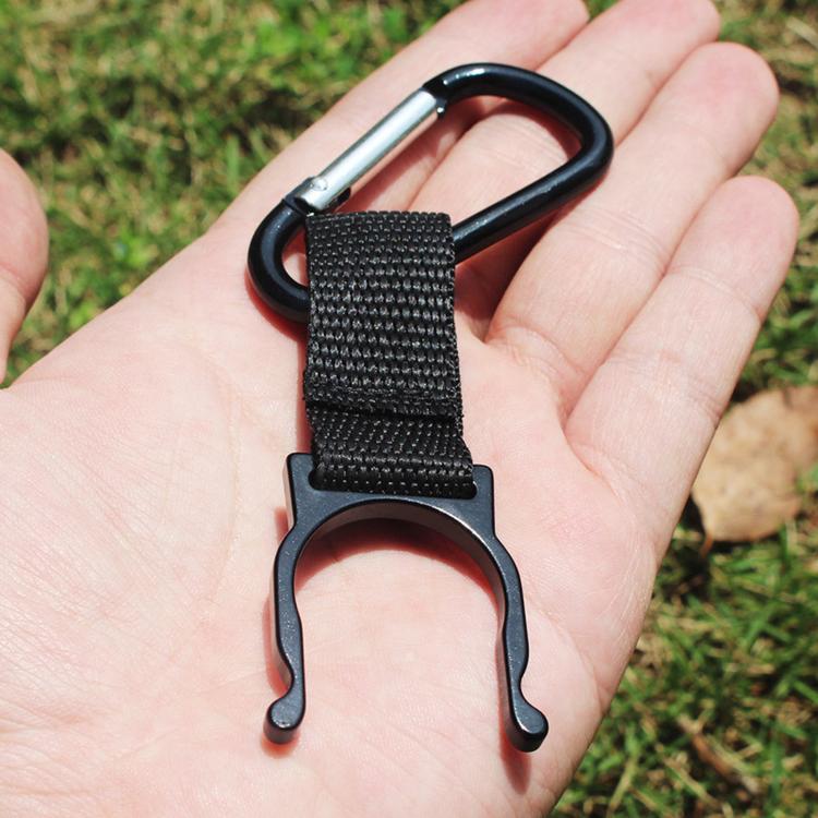 Black strap bottle holder clip with rounded metal hook, shown in palm