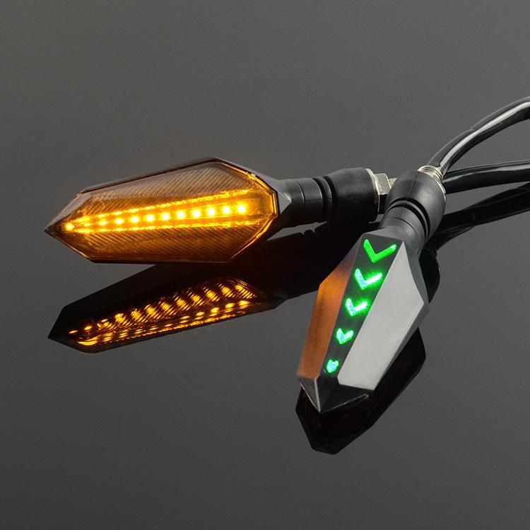Motorcycle LED turn signal pair with green sequential arrow LEDs and amber lens housing