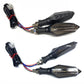 Motorcycle LED turn signal pair with wiring harness and dark arrow-shaped housings