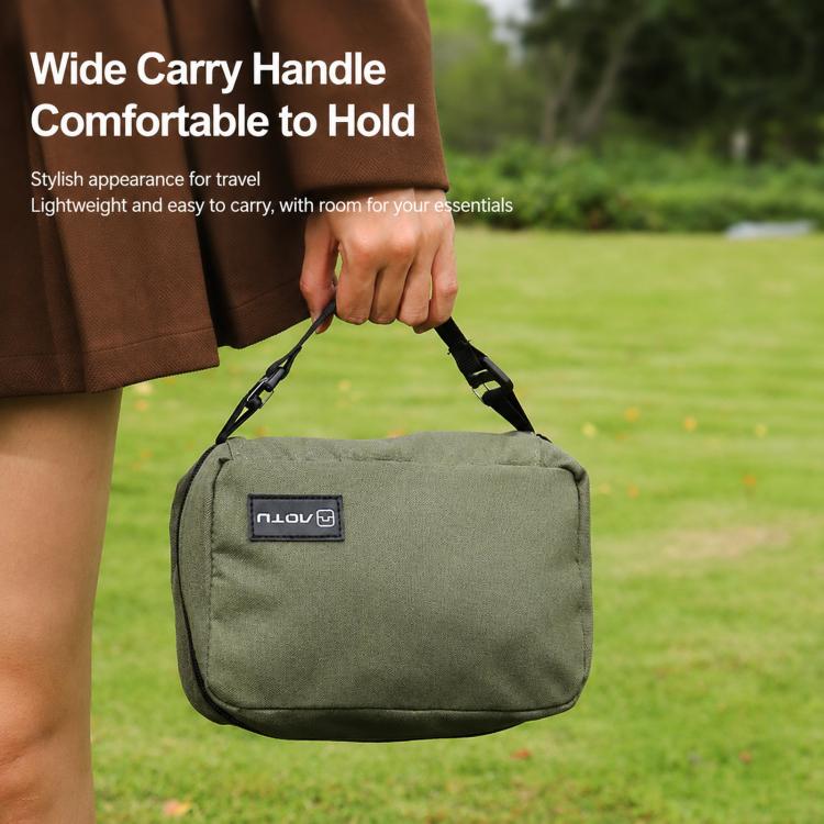 Army green toiletry bag held by its top carry handle