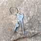 Key-shaped multitool keychain with key ring, blade, and bottle opener tool