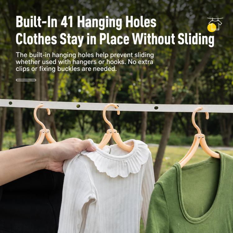 Retractable clothesline with white and green clothes hanging from holes on the line