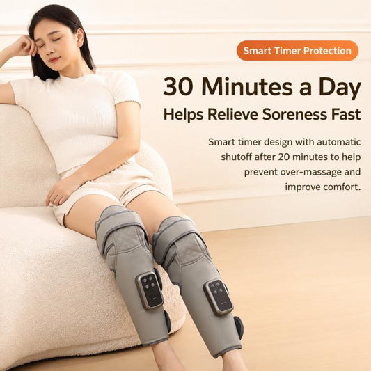 Gray leg air compression massager worn on calves and knees on a couch