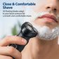 Black electric shaver with tri-blade head, shaving foam on the face