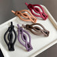 Assorted matte curved twist hair clips: black, purple, brown, peach, red-pink