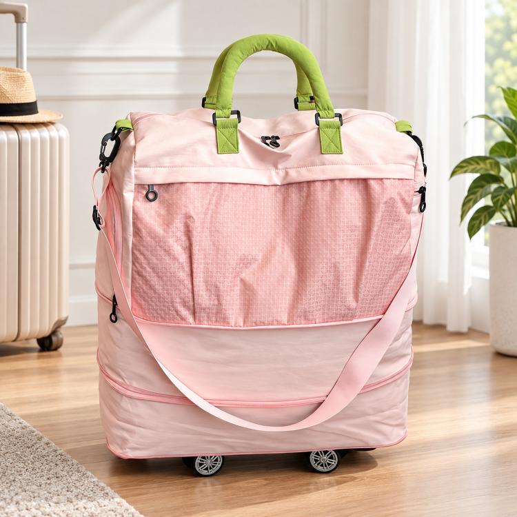 Pink nylon rolling duffel bag with green handles, zip top, and detachable wheels