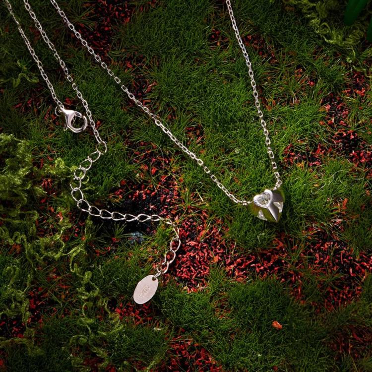 Heart-shaped moissanite pendant on sterling silver chain necklace with small charms