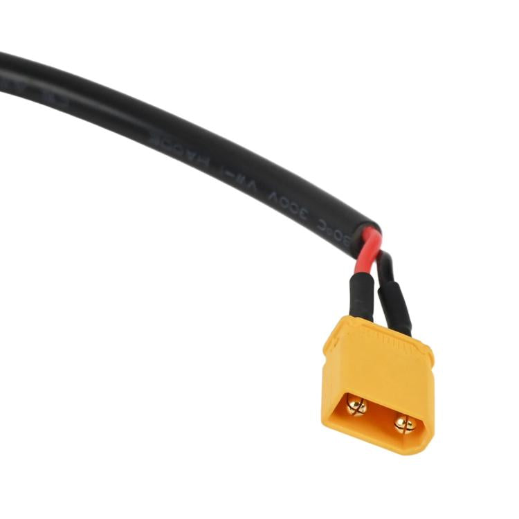 Yellow charging plug connector on black cable with red wire, close-up