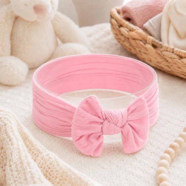 Pink infant bowknot headband with wide fabric band and large knotted bow at front