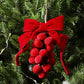 Red ribbon bow pom-berry grape-cluster wreath ornament, close-up