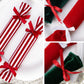 Close-up of striped and velvet plush candy ornaments with red ribbon bows