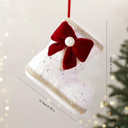White fabric Christmas boot ornament with red velvet bow and pearl bead center.