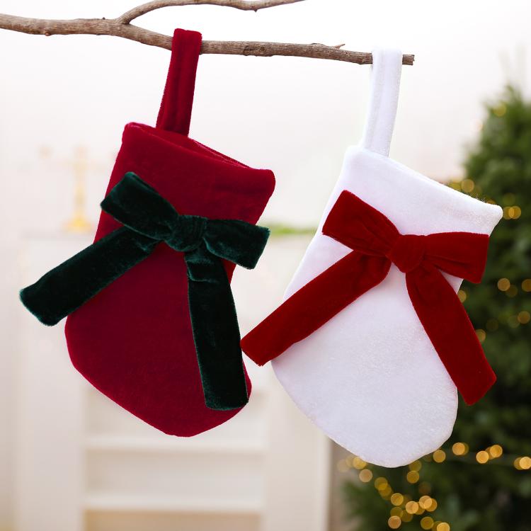 Hanging pair of stockings from a branch: red with green bow, white with red bow