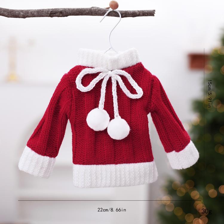 Mini knitted red sweater ornament with white hem and cuffs, bow tie, and pom pom details.