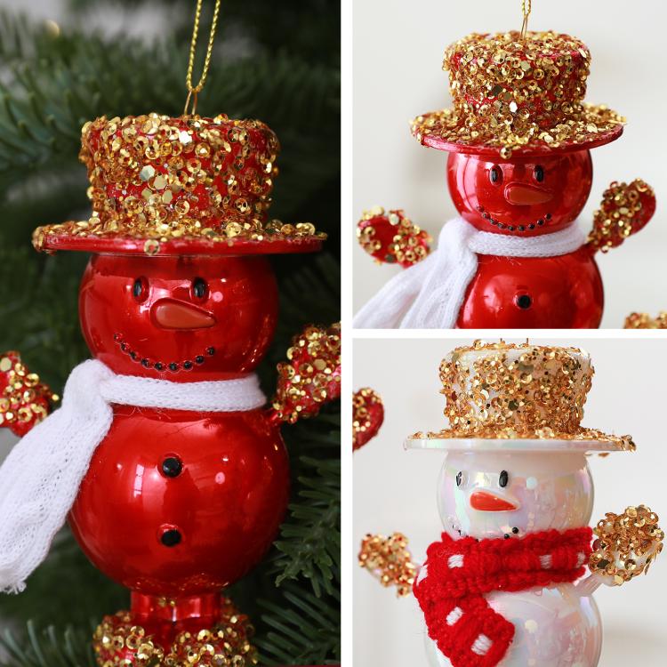 Two snowman ornaments: red one and white one with gold glitter top hats