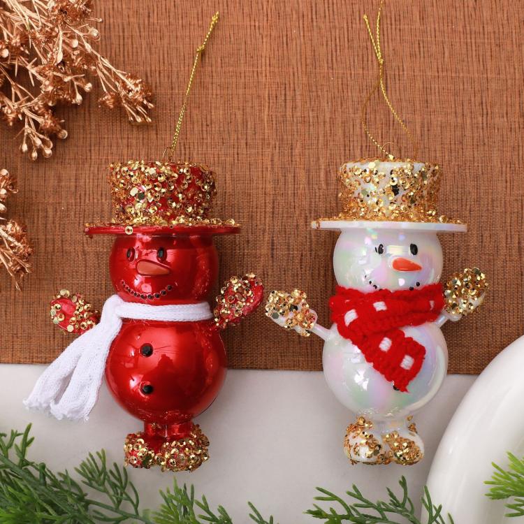 Two hanging snowman ornaments: red and white figures with gold glitter top hats