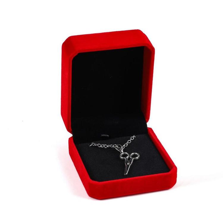 Red octagonal velvet jewelry box, open with silver-tone chain cross pendant