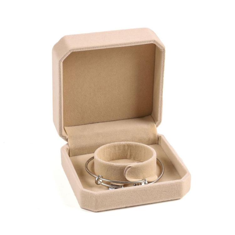 Beige octagonal velvet jewelry box, open with bracelets on round inner cushion