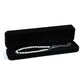 Black octagonal velvet jewelry box, open with pearl necklace and chain pendant