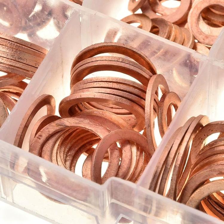 Copper crush washers assortment in clear container, close-up of mixed flat rings