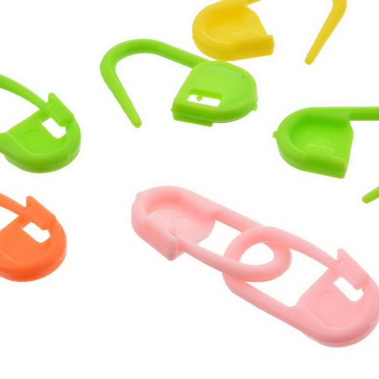 Close-up of green and pink plastic pin mark clips, U-shaped connectors