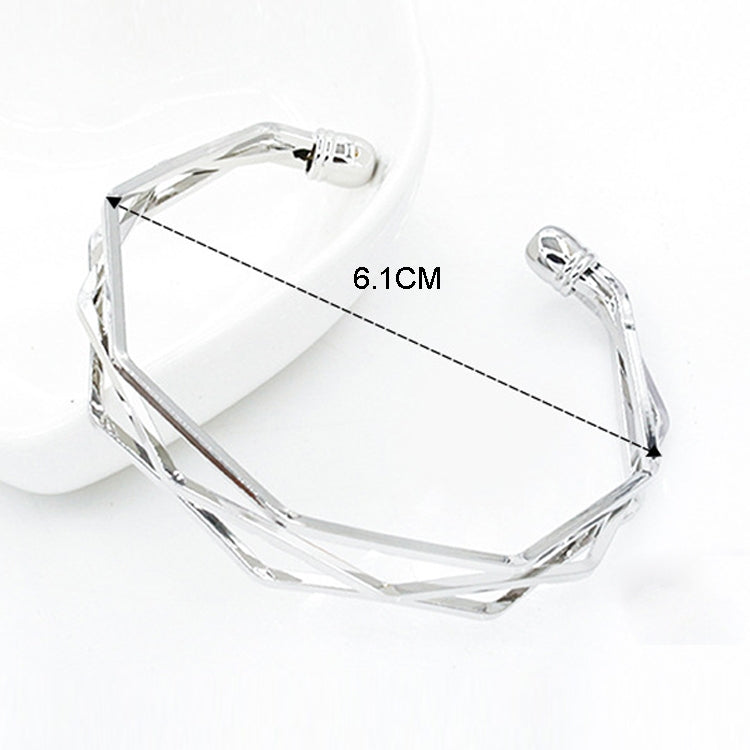 Silver multi-layer open cuff charm bracelet with faceted geometric links.