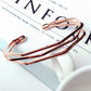 Rose gold multi-layer open cuff charm bracelet on a white tabletop display.