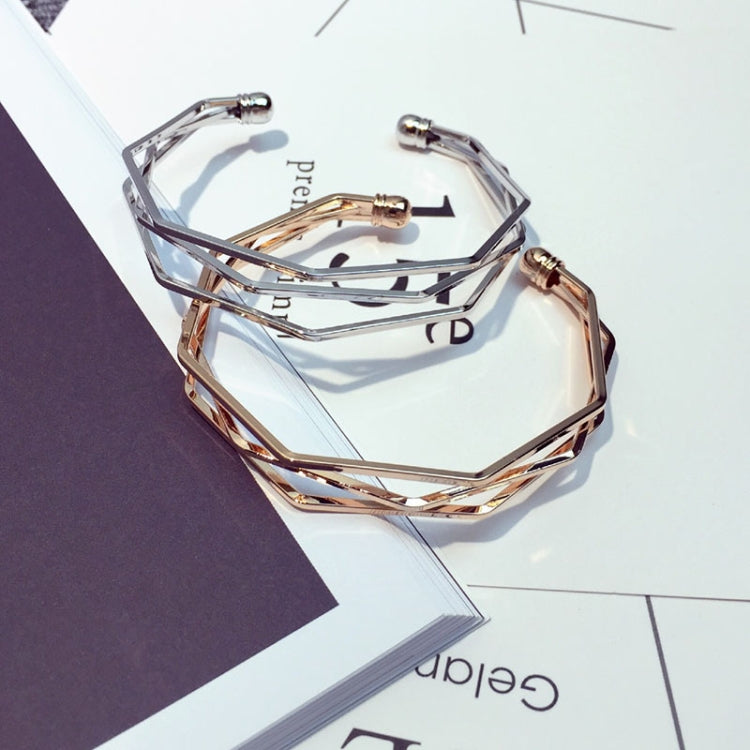 Stacked multi-layer open cuff bracelets in silver and rose gold geometric links.