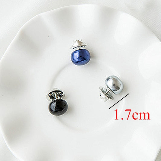 Assorted pearl collar pins with blue, silver, and black beads on display plate