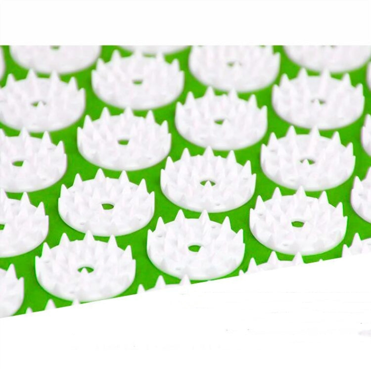 Close-up green acupuncture pad with white circular acupoint disks