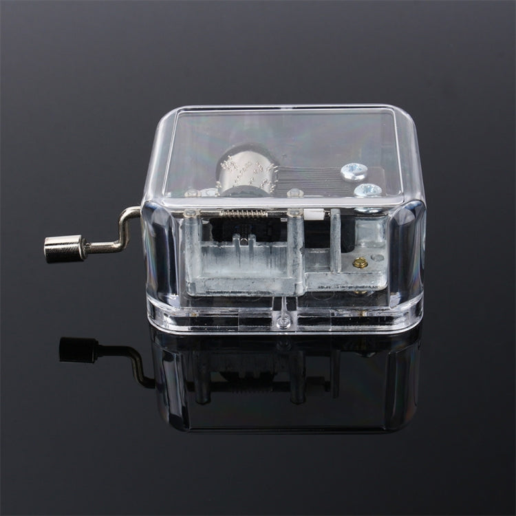 Clear acrylic DIY music box with exposed mechanism and two winding levers, front view