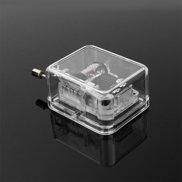 Clear acrylic DIY music box with exposed parts inside, angled 3/4 view