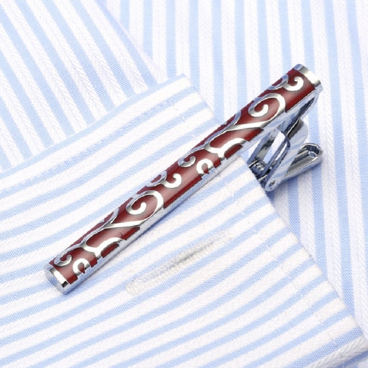 Red enamel tie clip with white scroll pattern and shiny silver clasp