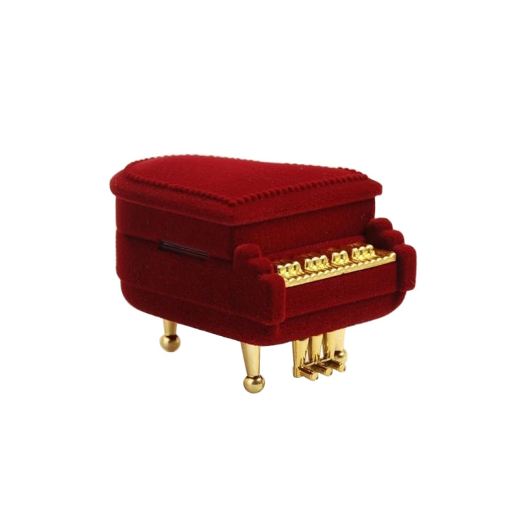 Red velvet piano-shaped jewelry box, closed with gold front detail and small black latch