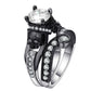 Triple-band skull ring with round clear center gemstone, black enamel details, silver stones