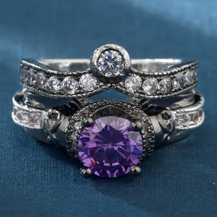 Skull ring with large purple round center gemstone, dark band, and silver sparkle accents