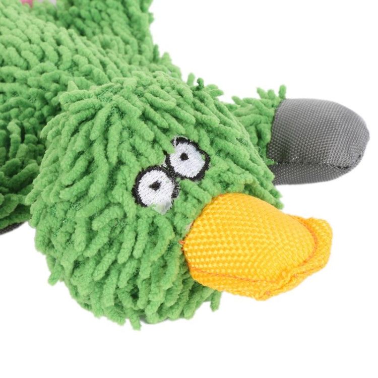 Green plush duck toy with stitched eyes and yellow beak, gray paw feet