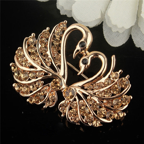 Gold-tone crystal swan brooch with rhinestone body and curved wings