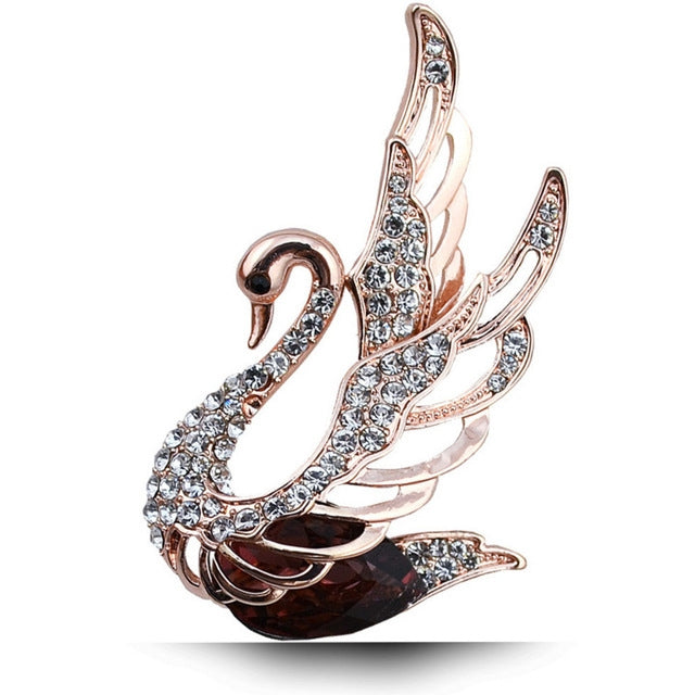 Rose-gold tone swan crystal brooch with clear stones and a dark central gem