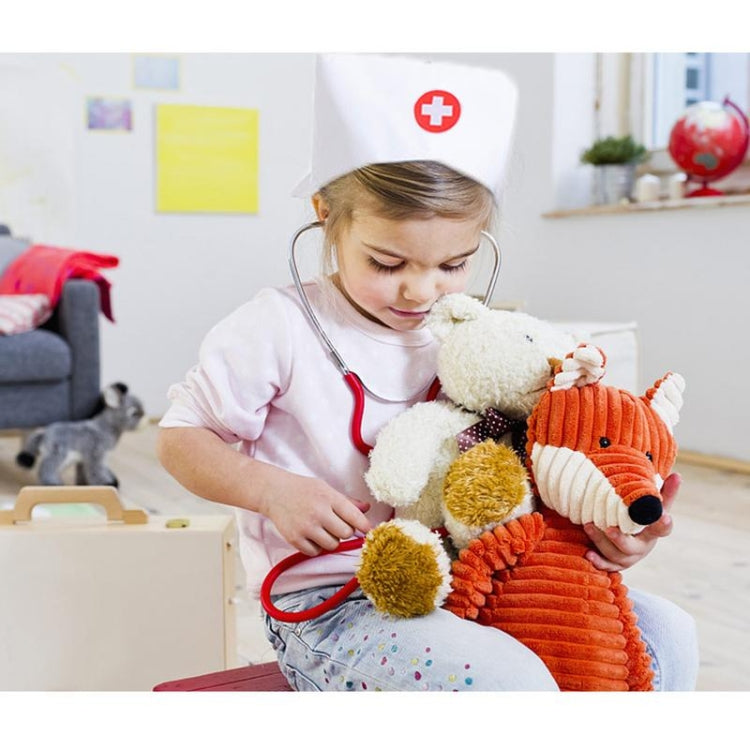 Pink nurse play costume with red cross cap, child seated with stuffed animals