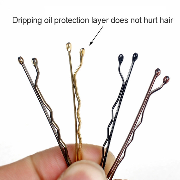 Assorted metallic hair pins in hand, gold and dark tone comb tips close-up
