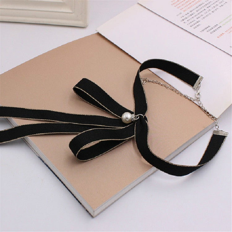 Women’s black ribbon bow tie with pearl button center and layered ribbon tails