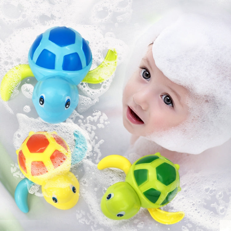 Set of colorful turtle bath toys floating near a child in bubbles