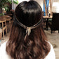 Gold tassel hair headband worn on dark hair, featuring a small rhinestone detail