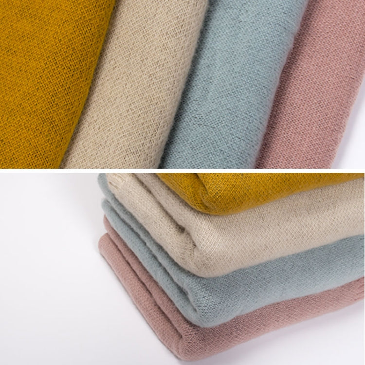 Folded thick knit scarves in pink, beige, and blue-gray with textured knit surface