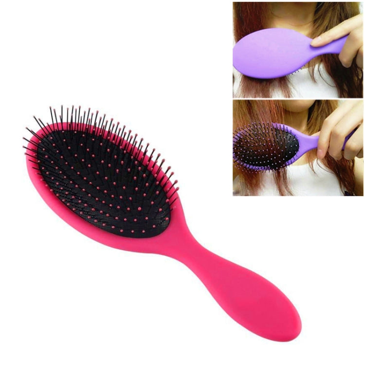Pink hair brush with oval black massage pad and short flex bristles