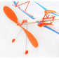 Close-up of orange propellers and wooden struts on a blue-and-white DIY rubber-powered glider.