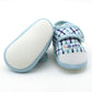 Baby prewalker shoes with blue plaid uppers and soft rubber sole, open heel view