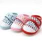 Baby prewalker shoes with plaid uppers, “Baby” label, and soft cushioned sole
