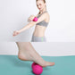 Pink silicone massage ball pair used under leg for self-massage and stretching